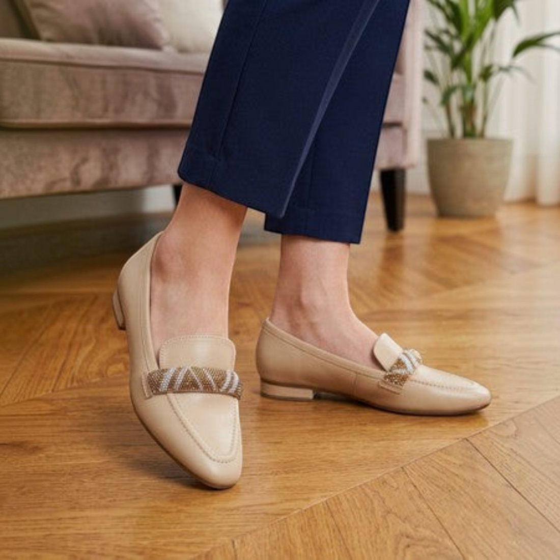 MOODBOARD beige microfibre pump loafers with a decorative beaded strap worn with navy trousers on a wooden floor