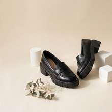 MOODBOARD Beira Rio black synthetic loafers with a chunky block heel and minimalist design on a neutral background.