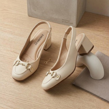 MOODBOARD Everbest beige leather slingback pumps with gold horsebit detail and block heels on a wooden surface.