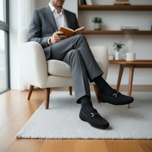 MOODBOARD Jaguar gents loafers in black suede with silver horsebit detail worn by a man in a grey suit